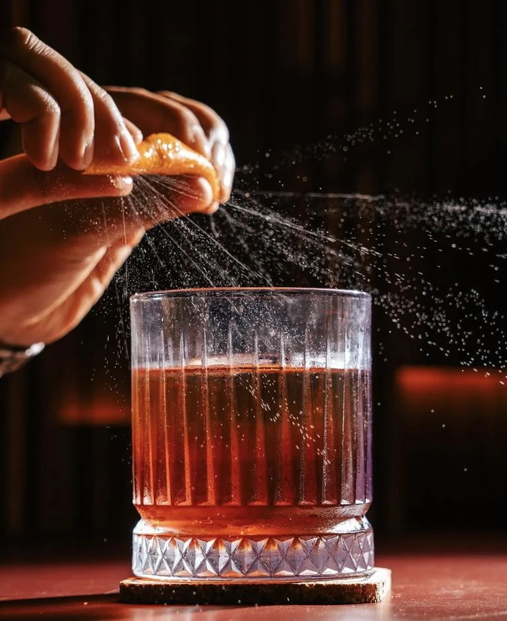 Orange oils expressed over a finished cocktail